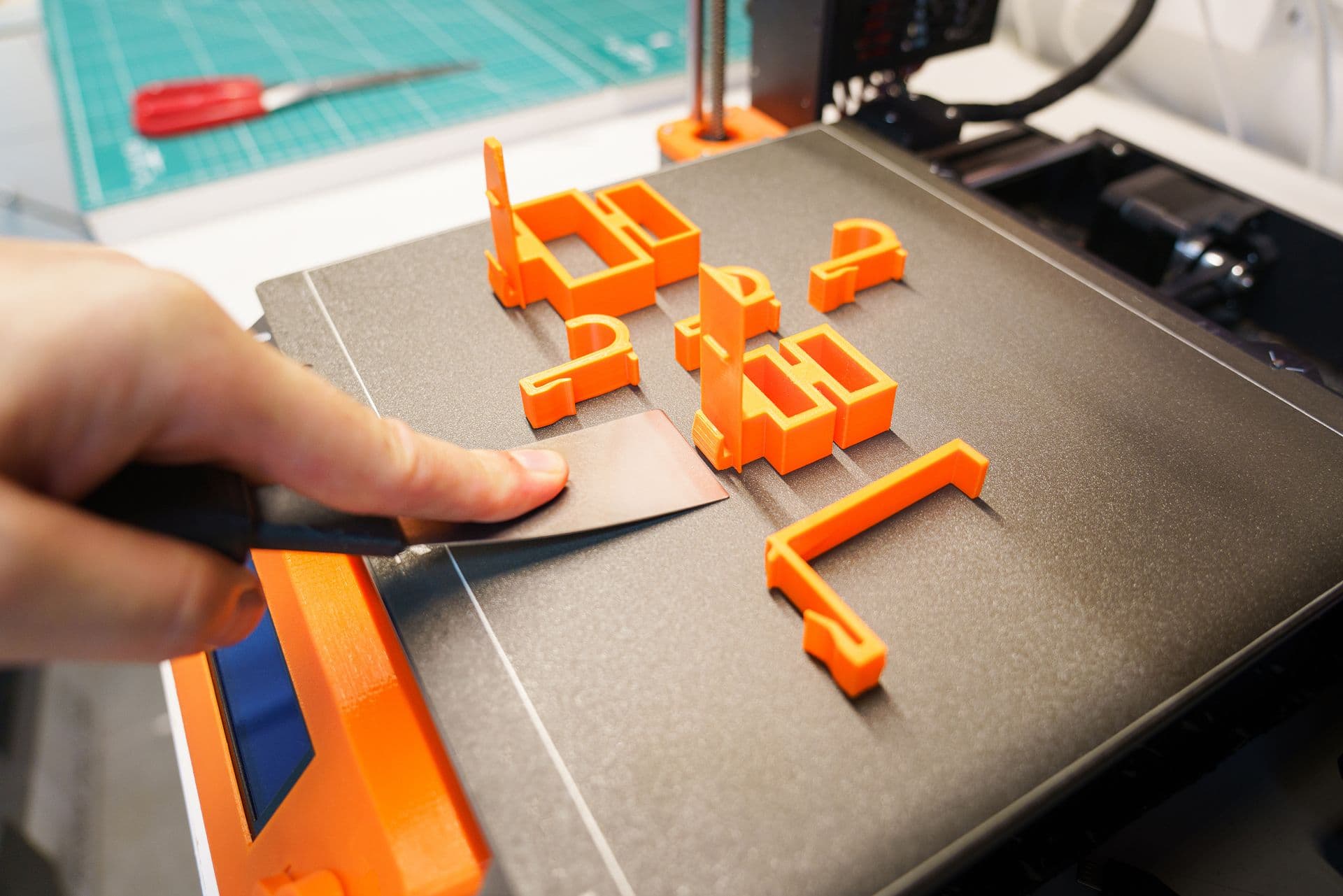 Printed brackets and clips lifted off the build plate